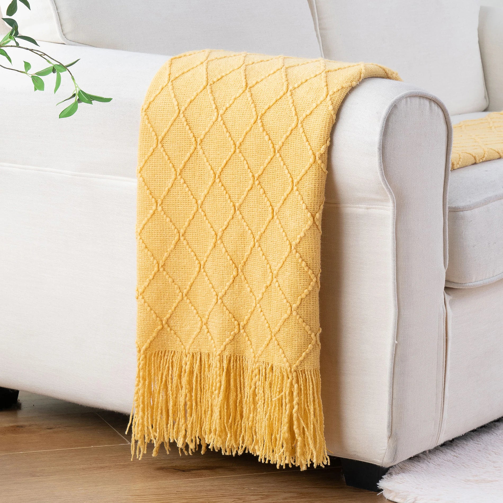 Battilo Plaid Knitted Throw Blanket Soft Woven Throws Sofa Blanket draped over a sofa arm.