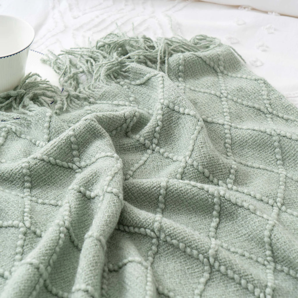 Battilo Plaid Knitted Throw Blanket Soft Woven Throws Sofa Blanket draped over a sofa arm.