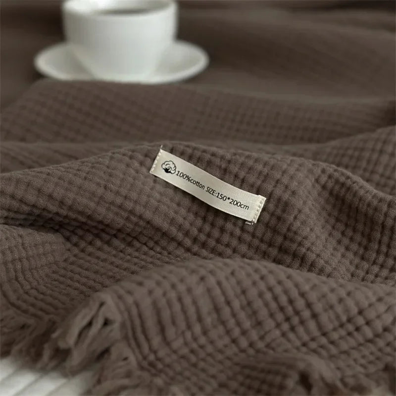 1pc Blanket 100% Cotton Sofa Towel Tassels Bed Linen Solid Color Shawl manta Skin-friendly Plaid Home Blankets draped on a sofa.