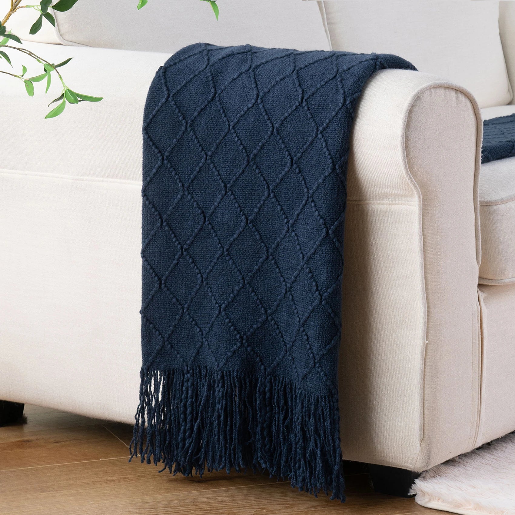 Battilo Plaid Knitted Throw Blanket Soft Woven Throws Sofa Blanket draped over a sofa arm.