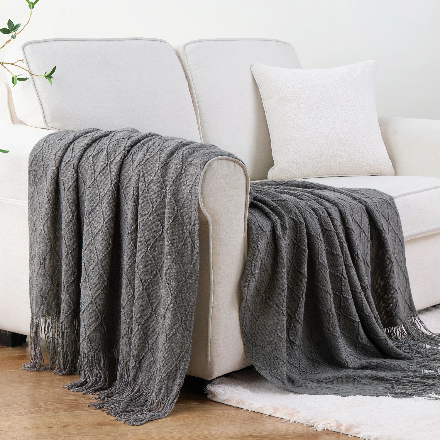 Battilo Plaid Knitted Throw Blanket Soft Woven Throws Sofa Blanket draped over a sofa arm.