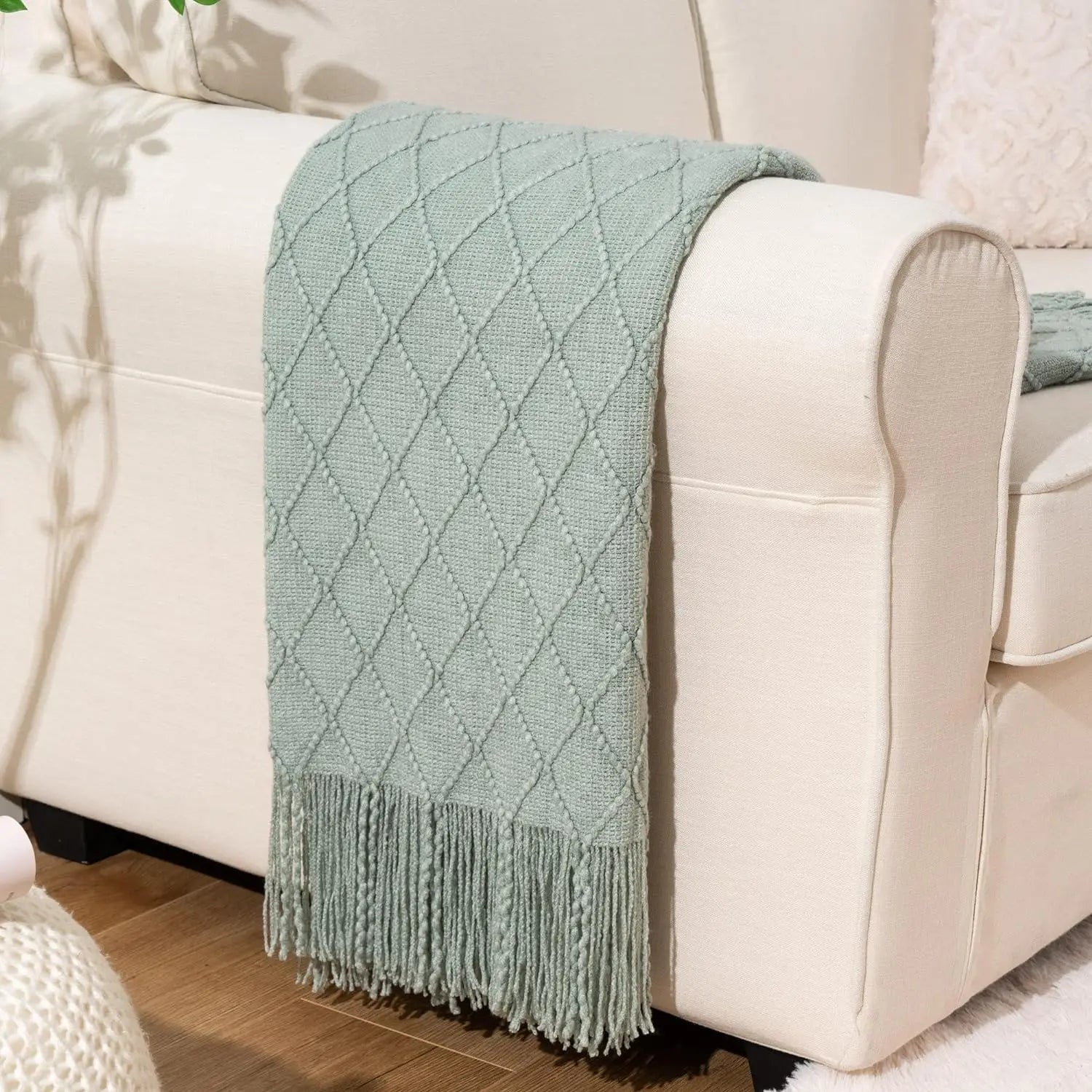 Battilo Plaid Knitted Throw Blanket Soft Woven Throws Sofa Blanket draped over a sofa arm.