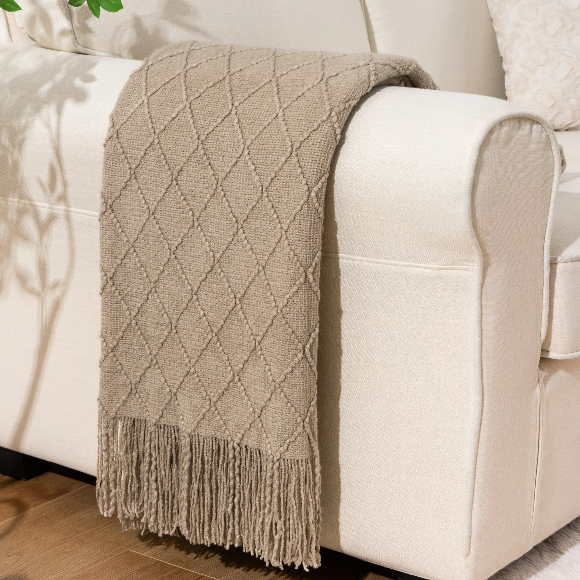 Battilo Plaid Knitted Throw Blanket Soft Woven Throws Sofa Blanket draped over a sofa arm.