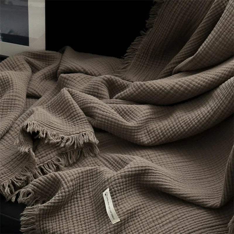1pc Blanket 100% Cotton Sofa Towel Tassels Bed Linen Solid Color Shawl manta Skin-friendly Plaid Home Blankets draped on a sofa.