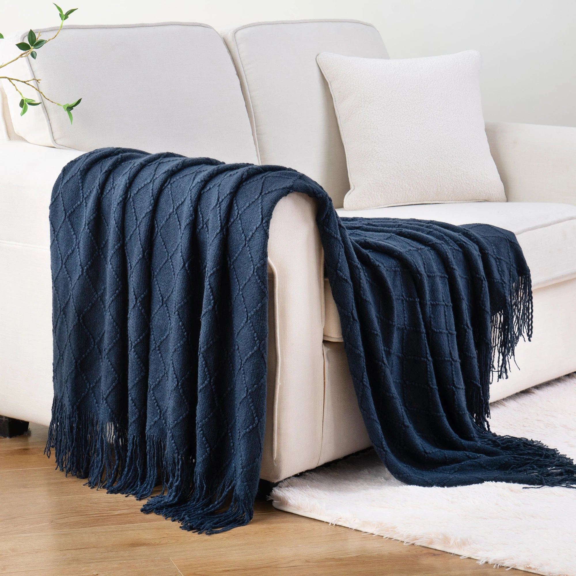 Battilo Plaid Knitted Throw Blanket Soft Woven Throws Sofa Blanket draped over a sofa arm.