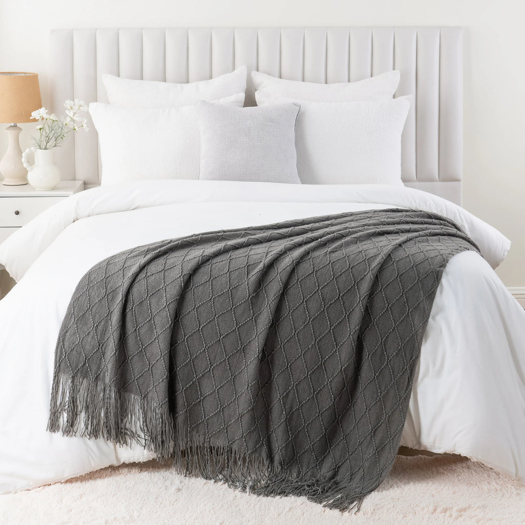 Battilo Plaid Knitted Throw Blanket Soft Woven Throws Sofa Blanket draped over a sofa arm.