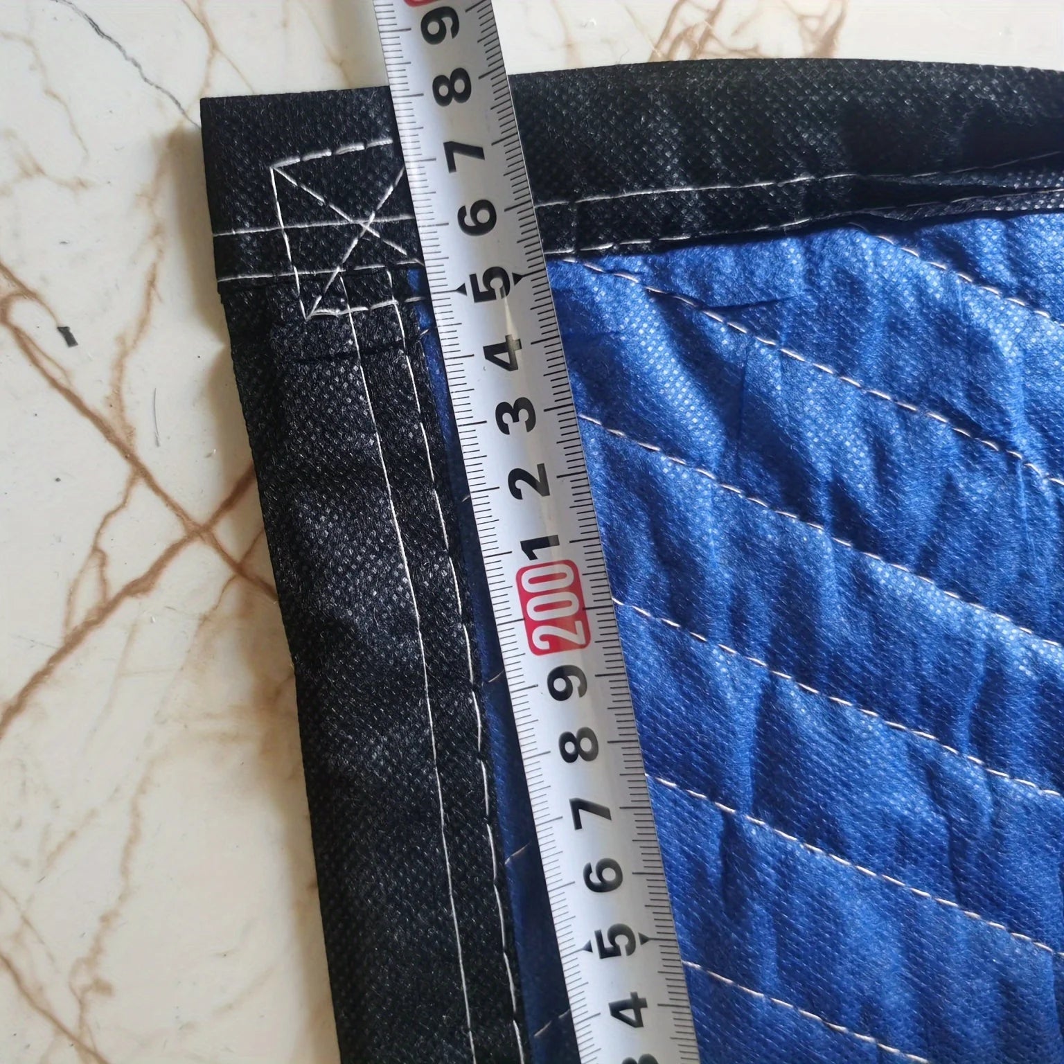 Mobile blanket-- heavy-duty packaging blanket folded, showcasing blue and black fabric textures.