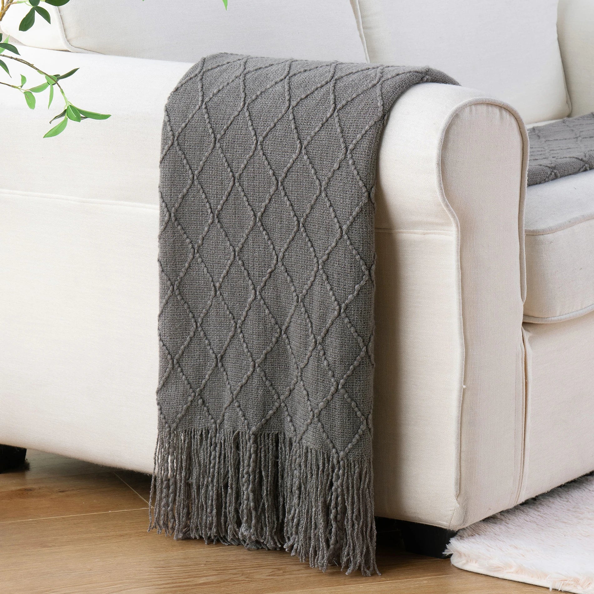 Battilo Plaid Knitted Throw Blanket Soft Woven Throws Sofa Blanket draped over a sofa arm.
