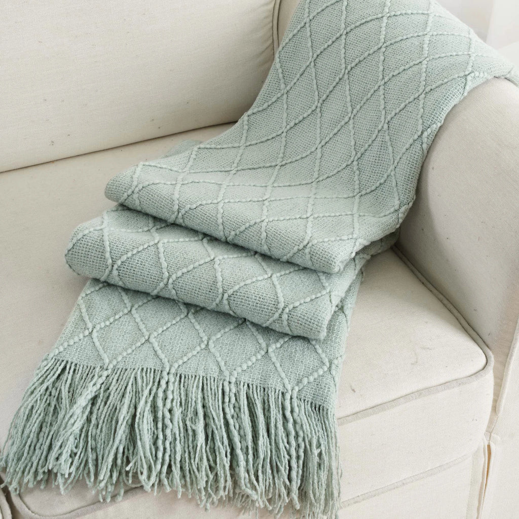 Battilo Plaid Knitted Throw Blanket Soft Woven Throws Sofa Blanket draped over a sofa arm.